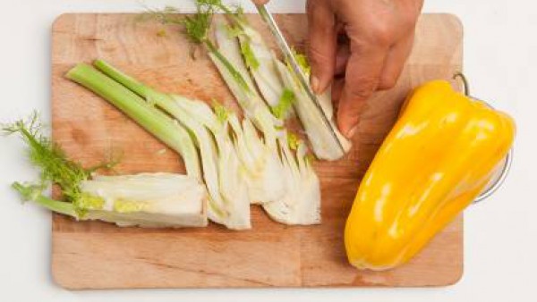Lava y limpia las verduras, corta el hinojo en rodajas finas, los pimientos en tiras y las zanahorias en rodajas finas.