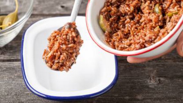 Escurre el arroz, añade el sofrito, sal y pimienta y agrega las alcaparras. Sirve la ensalada con arroz salvaje en una tabla.