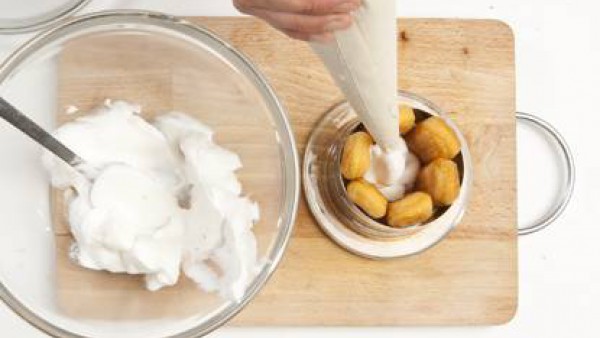 Con la ayuda de unos anillos de pastelería, recúbrelos por dentro con los bizcochos y con una manga pastelera rellénalos de crema.