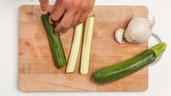 Lava y corta el calabacín en pedazos largos finos; pela y pica finamente la cebolla y el ajo.