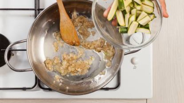 En una sartén, rehoga el ajo y la cebolla con 1 cucharada de aceite de oliva virgen extra; añade el calabacín y cocina brevemente.