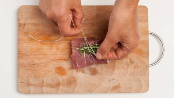Prepara el filete de cerdo atándolo con una ramita de romero y salvia. En una sartén, saltea 1 diente de ajo con el aceite de oliva virgen extra; añade el lomo de cerdo y el Avecrem Dúo Guisos de Carn