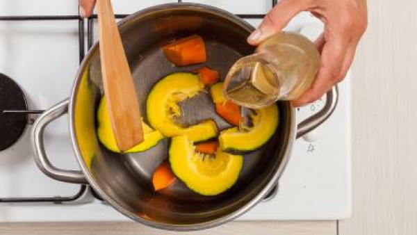 En una olla grande, sofríe el ajo con 2 cucharadas de aceite de oliva, añade la calabaza y las zanahorias y el caldo. Tapa y cocina en una olla durante 15 minutos.