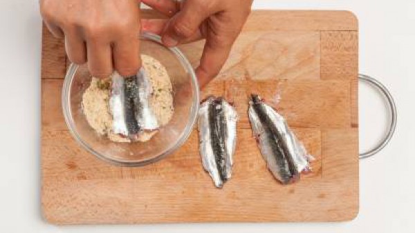 Limpia las sardinas, elimina las vísceras, la cabeza y los huesos. En un bol, prepara el relleno con pan rallado, el ajo, el perejil y el queso de oveja rallado. Vierte en la mezcla 1 taza de caldo he