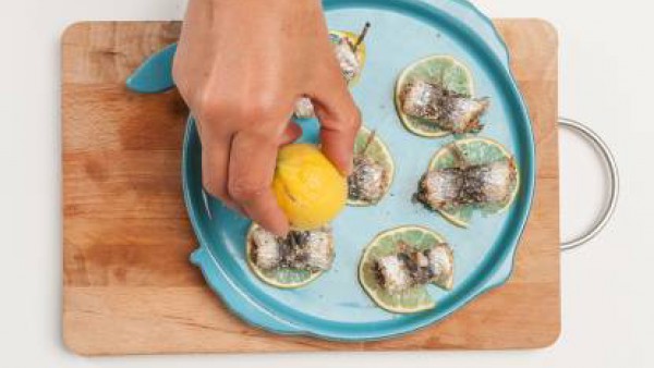 Sazona el limón con laurel desmenuzado y dispón una sardina encima de cada limón. Después, riégalo todo con un poco de aceite de oliva. Hornea las sardinas a 180 ° C durante 15 min. A continuación, re