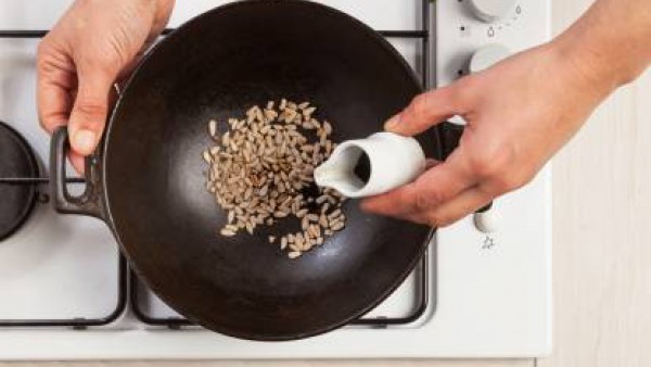 Añade el arroz y cocinar por lo menos durante 18 min. Agrega caldo siempre que sea necesario. Por separado, tuesta las semillas de girasol en un wok caliente, añadiendo después la salsa de soja.