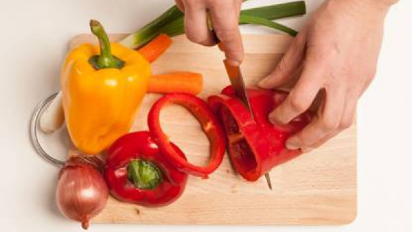 Lavar las verduras; corta en dados los pimientos y zanahorias y pica finamente la cebolla y la cebolleta. 
