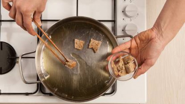 Freír el pan en la sartén con un poco de aceite para obtener los trocitos de pan crujiente. Servir como acompañamiento de verduras.
