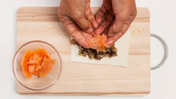 Rellena los hojaldres con un poco de achicoria y unas tiras de salmón. Dobla los rectángulos uniendo dos untas opuestas y dándole forma redondeada. Asegúrate de unir bien los bordes y repite la operac