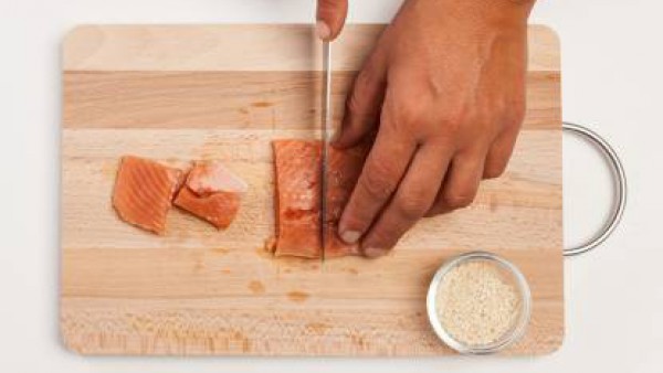 Corta el salmón en trozos, y pásalo por las semillas de sésamo. Luego, colócalos en una sartén con un poco de aceite de oliva virgen extra bien caliente y dóralos.