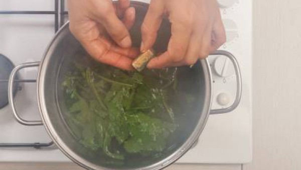 En una cacerola de bordes altos, rehoga la cebolla con 1 cucharada de aceite de oliva virgen extra; a continuación, añade los grelos y el Avecrem.