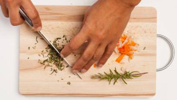 Por otro lado, limpia y pica las zanahorias, la cebolla picada y el romero. En un wok, prepara la salsa con una cucharada de aceite de oliva, la cebolla picada y la zanahoria. A continuación, añade el