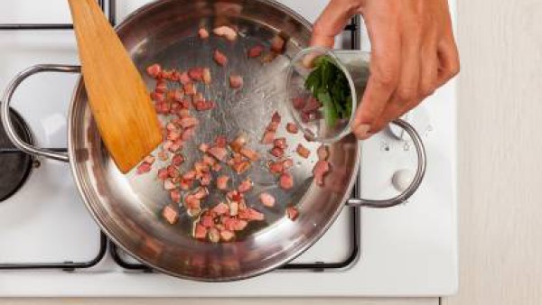 Corta el bacon en cubos y pica el cilantro fresco. En una sartén, fríe el bacon en un poco de aceite de oliva y agrega el cilantro.