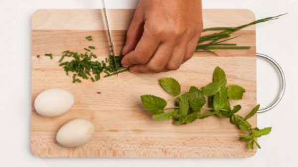 En una tabla de cortar, coloca las hierbas y pícalas finamente. Por separado, prepara el relleno mezclando 3 cucharadas de salsa pesto y el queso.