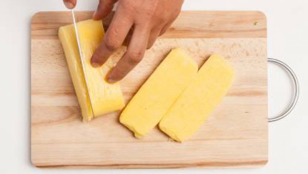 Mientras tanto, corta la polenta precocida en rebanadas con el espesor de alrededor de 1/2 cm.