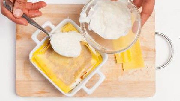 Rellena la lasaña, alterando una capa de salsa boloñesa y Mi Salsa Bechamel. Cubre con una última placa de lasaña y añade queso rallado. Hornea durante 15 minutos y sirve.