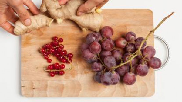 Pela el jengibre, rállalo y exprime el jugo. Lava y limpia la fruta; separa las semillas de la granada de las bayas, pela la uva. Exprime el jugo de medio limón. Por separado, hierve una taza de agua 