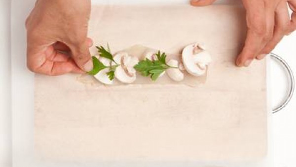 Prepara los cartuchos con los filetes de pescado, las setas, las hojas de perejil y baña con el caldo. Cuece en el horno a 180 grados durante 15 minutos.
