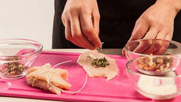 Prepara los rollitos rellenando los filetes de pavo con hierbas y nueces picadas, el queso rallado y una loncha de queso para fundir. Ata los rollitos con hilo de cocina. Fríe en aceite de oliva virge
