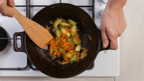 En un wok, saltea la cebolla, añade las coles de Bruselas, las zanahorias ralladas y la pastilla de Avecrem Dúo de Tomate desmenuzada. Cuece durante 10 minutos.