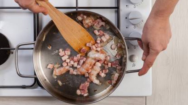 Rehoga las chalotas en una sartén y añade el bacon cortado en dados. A continuación, añade los langostinos, 1/2 vaso de agua y 1 pastilla de Avecrem Dúo Paella de Pescado; cocínalo todo durante 10 min