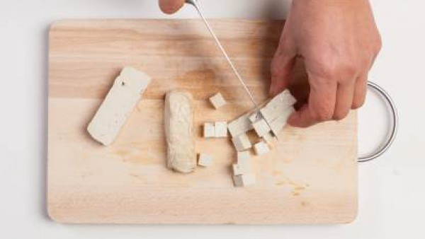 Corta el tofu en dados. Pon la cebolla en una sartén con aceite de oliva, añade el tofu y fríelo durante 5-6 minutos.