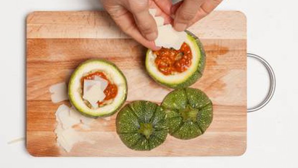 En un bol, corta la carne de los calabacines con la menta y la albahaca. Añade el cuscús y mezcla bien. Rellena los calabacines con la mezcla.
