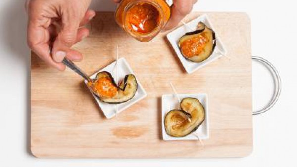 Con un palillo largo o brocheta de madera ensarta la rebanada de berenjena, formando una especie de media luna y rellena con una cucharada de Sofrito de Tomate y Verduras Gallina Blanca.
