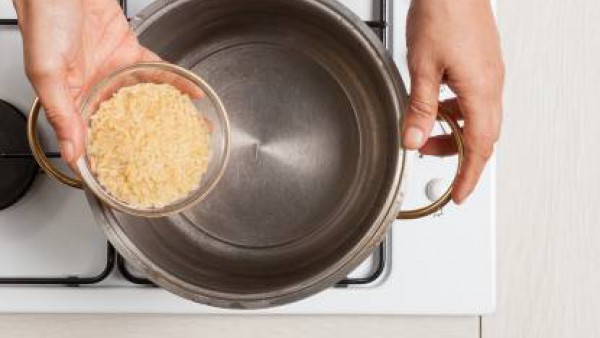 Cuece el arroz en agua con 1 pastilla Avecrem Caldo de Pollo hasta que esté al dente. Mientras tanto lava los pimientos, corta las tapas y vacíalos de semillas. 