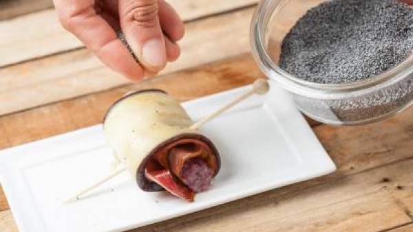 Da forma a los rollitos, sujétalos con un pincho y decora con semillas de amapola.