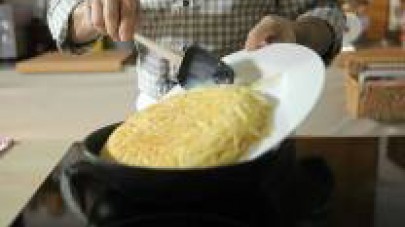 En una paella cuina la barreja d’ou i espaguetis